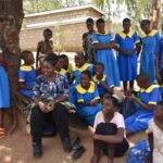 Deputy Minister of Education Nancy Chaola Mdooko with Chiwale Primary School students in Mwanza
